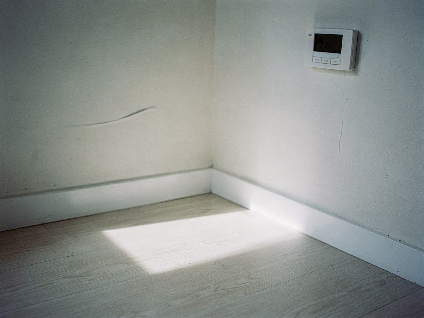 Daylight across the floor of an empty apartment room