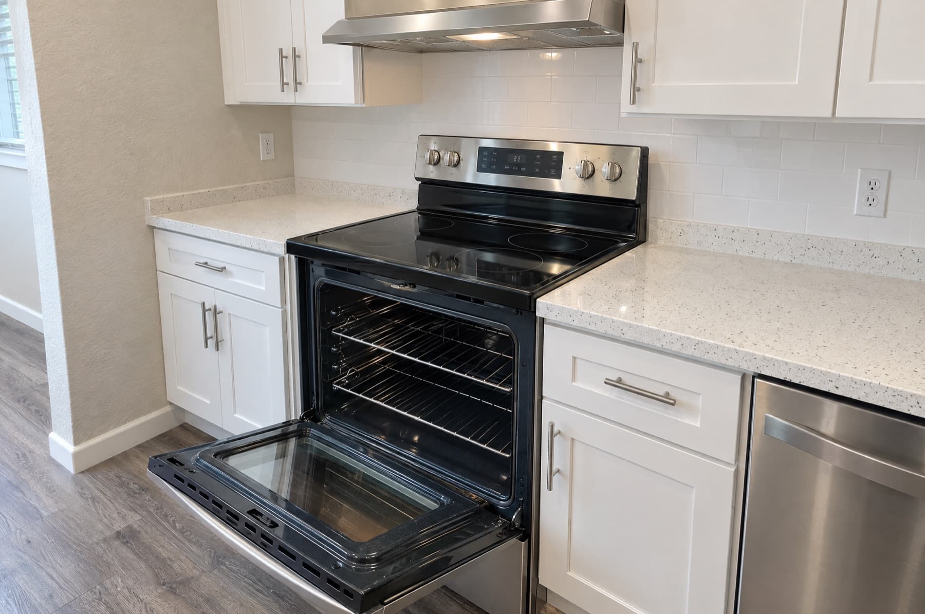 Open oven interior, white kitchen cabinets and counters